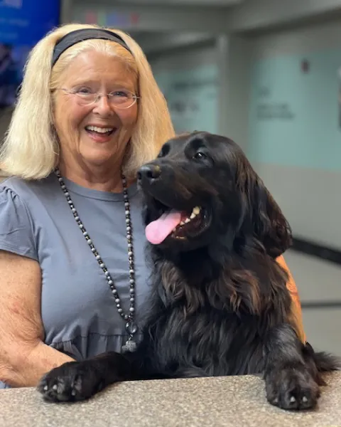 Flip, a black Newfoundland and Golden Retriever mix, with his handler Barbara