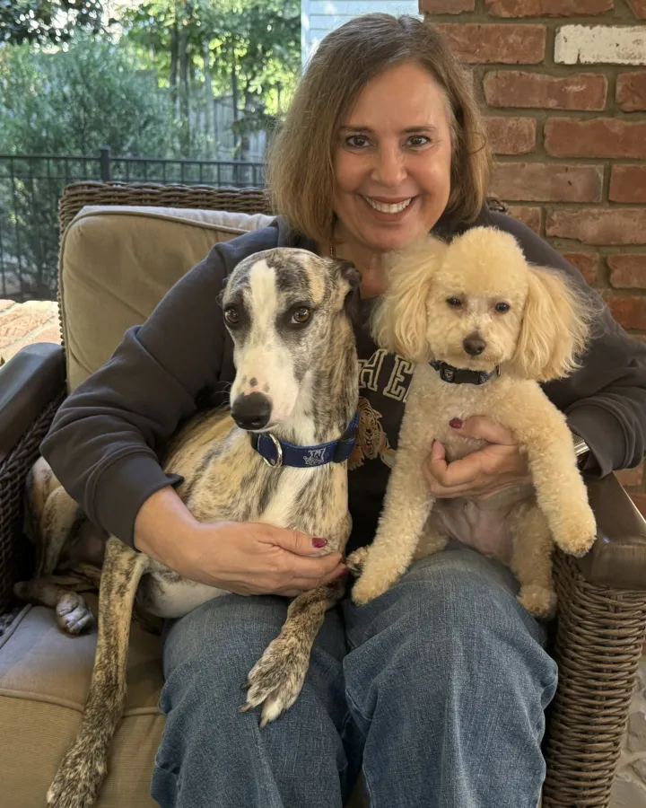 Tonia with her dogs Jet, a brindle whippet, and Roi, a small cream-colored mixed breed