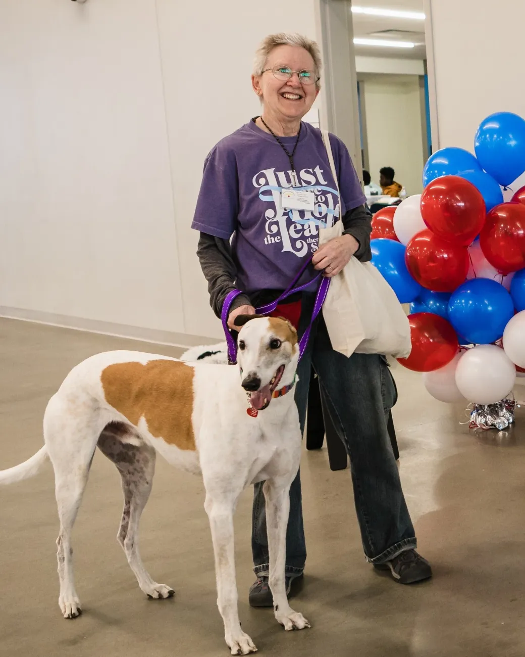 Simon, a white and tan greyhound, with his handler Kathy